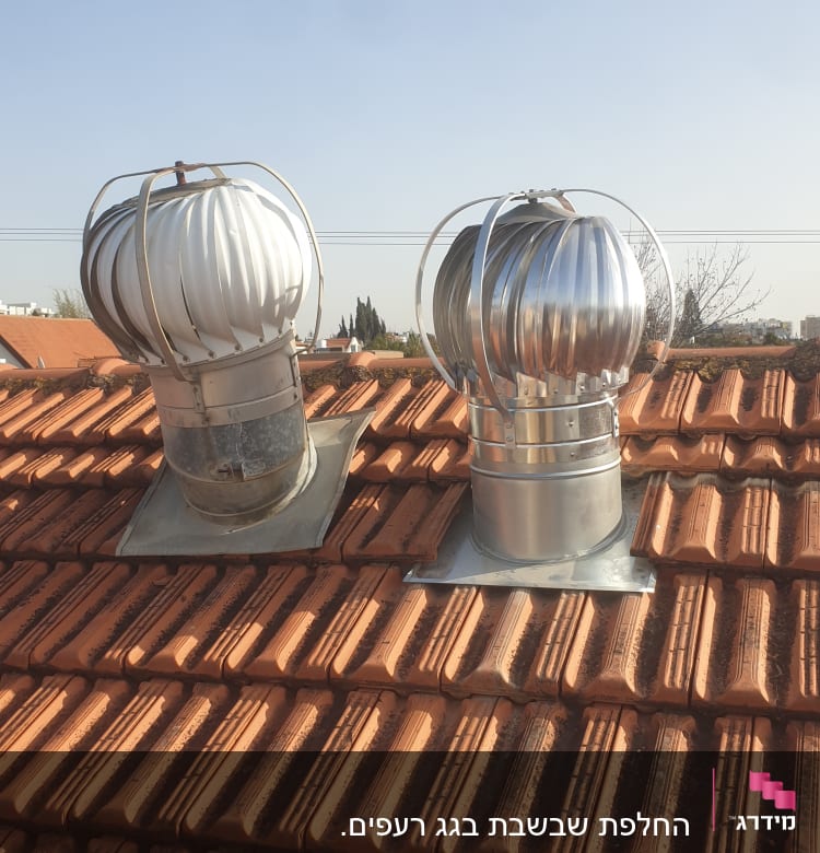 שני ונטות מתכת על גג רעפים אדום